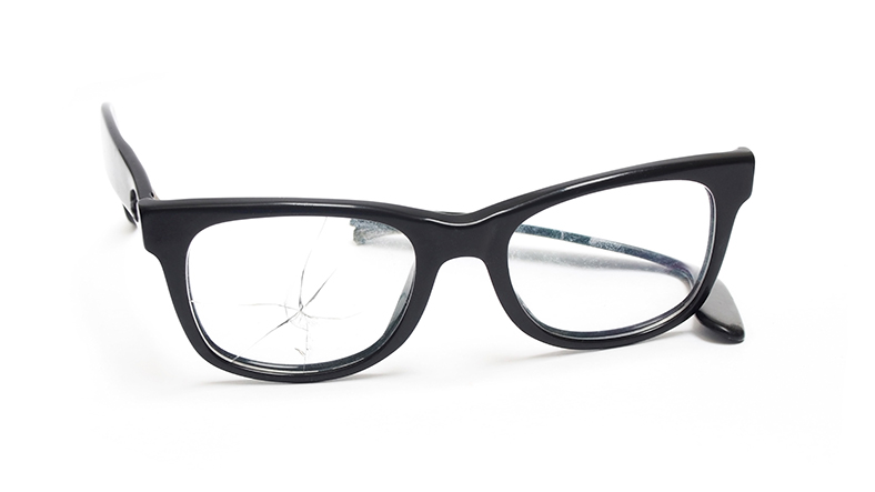Brille mit dunklem Rahmen und Sprung im Brillenglas.