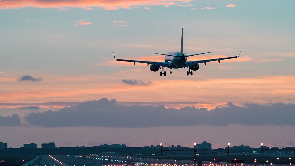 Flugzeug hebt bei Einbruch der Dunkelheit vom Rollfeld ab