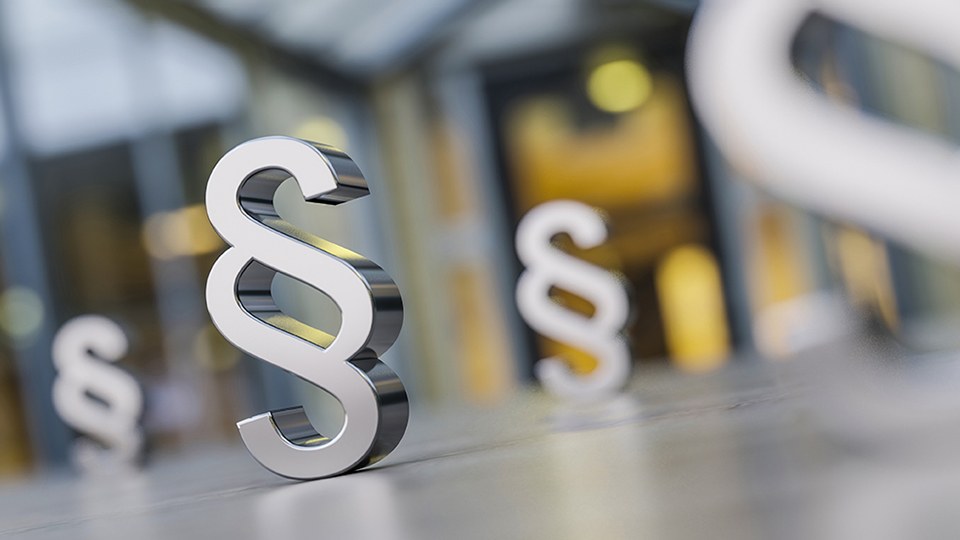 Paragrafensymbole stehen auf dem Boden einer Büroumgebung