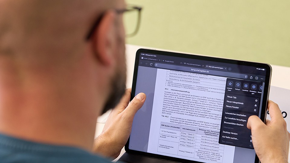 Blick über die Schulter eines Seminarteilnehmers auf dessen Tablet, auf dem eine Word-Datei aus dem BG ETEM-Learningportal geöffnet ist.