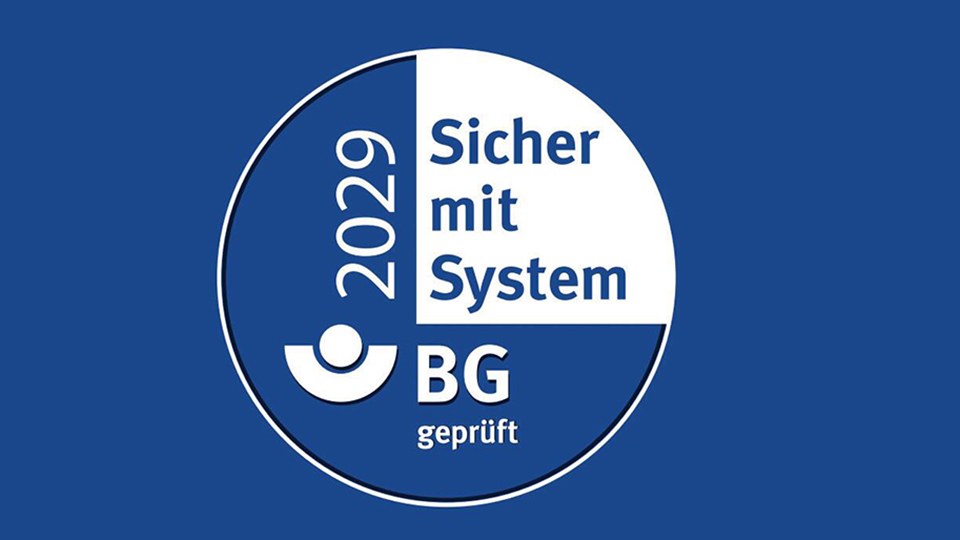 Rundes blau-weißes Siegel zur AMS-Zertifizierung; es zeigt das BG-Logo sowie den Text 2029, Sicherheit mit System und BG geprüft.