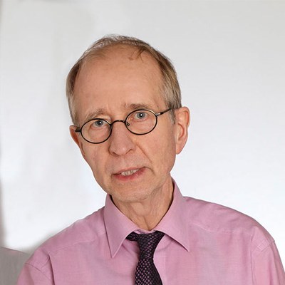 Porträtbild von Ralf Besser, Trainer, Coach und systemischer Berater. Er trägt eine Brille und ein rosafarbenes Hemd.