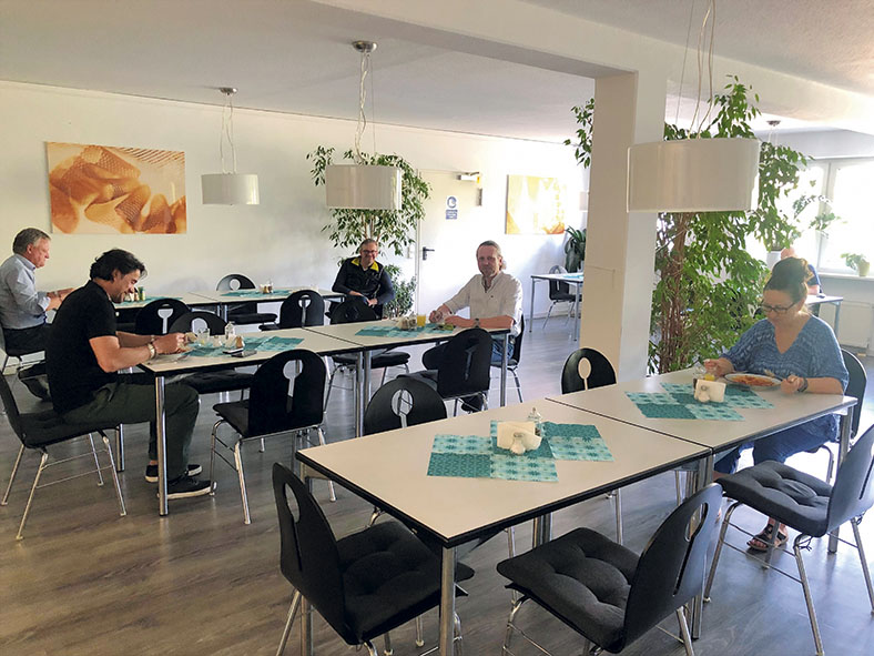 Kantine der Firma Topp Textil GmbH in Durach, mehrere Mitarbeiterinnen und Mitarbeiter sitzen mit großen Abstand an den Tischen, es ist ein Mindestabstand von 1,50 m einzuhalten.
