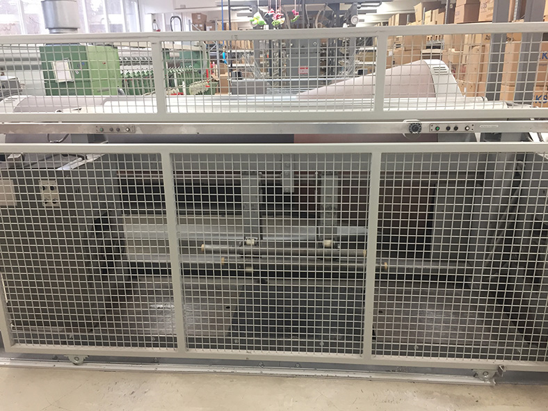 Konusschärmaschine in einer Fabrikhalle mit geschlossenem Schutzgitter.