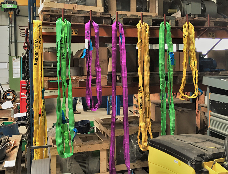 Mehrfarbige Bänder hängen in einem Lagerraum.