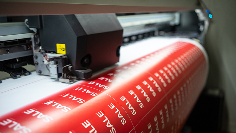 Druckmaschine mit Etikettenbogen in rot. 