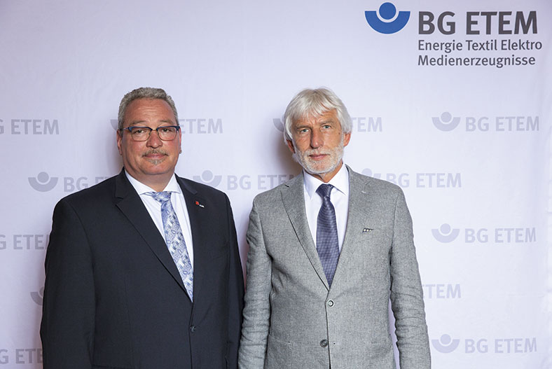 Das Bild zeigt von links nach rechts die Vorsitzenden des BG ETEM-Vorstands, Hans-Peter Kern und Dr. Bernhard Ascherl. Sie tragen beide einen Anzug und stehen nebeneinander vor einer BG ETEM Stellwand.
