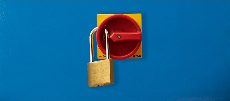 Die Abbildung zeigt einen roten Schalter mit einem Vorhängeschloss.