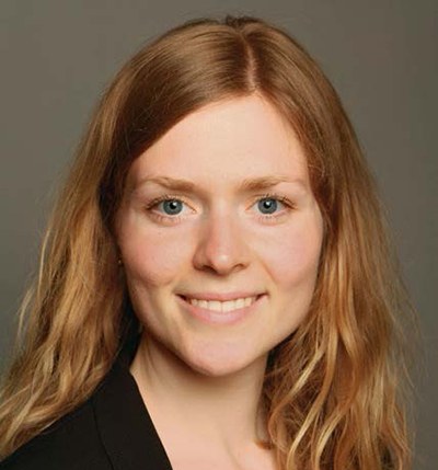 Porträtfoto von Jella Heptner, Arbeitspsychologin bei der BG ETEM. Frau Heptner hat längere rotblonde Haare, trägt ein dunkles Oberteil und lächelt in die Kamera.