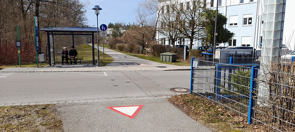 Straße mit kreuzendem Fahrradweg und Warnzeichen