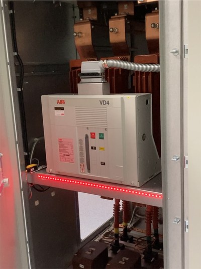 Elektrischer Kasten steht in einem Technikschrank, eine rote Lichtleiste leuchtet.