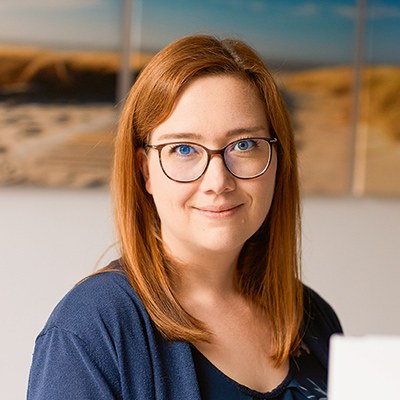 Porträt einer jüngeren Frau, die in die Kamera lächelt
