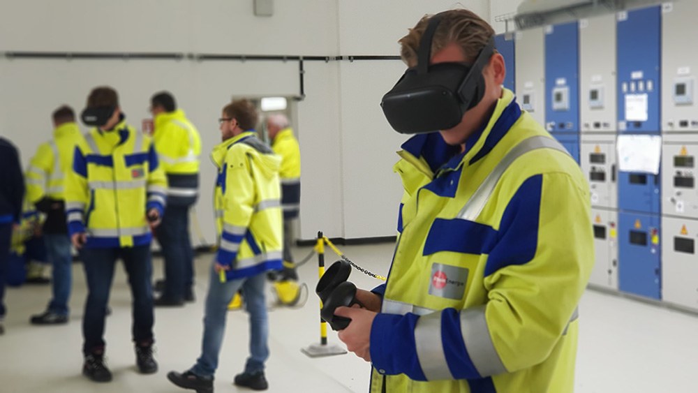 Virtuelle Realität: Mehrere Personen mit blaugelben Sicherheitsjacken beim Sicherheitstraining in einem Raum, einige tragen eine VR-Brille.