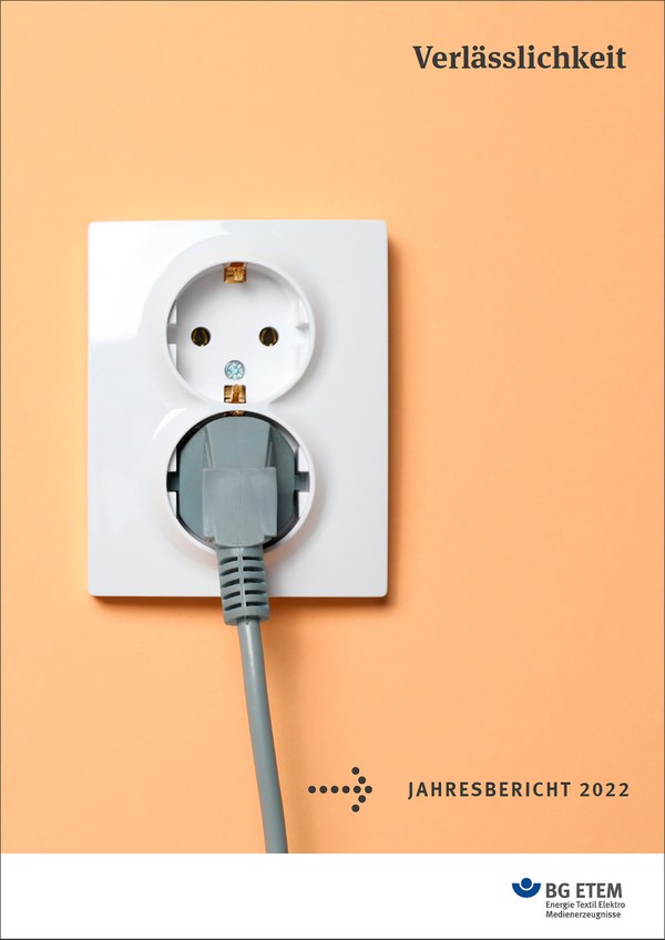 Arbeitsunfälle: Cover des Jahresberichtes der BG ETEM 2022 zeigt eine lachsfarbene Wand mit einer Doppelsteckdose und einem grauen Kabel.