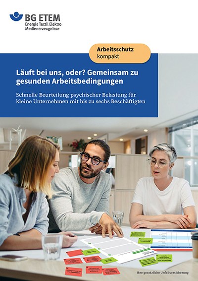 Titelseite der BG ETEM Broschüre Läuft bei uns, auf der drei Personen abgebildet sind, die gemeinsam an einem Tisch im Gespräch kleine Karteikarten zwei Plänen zuordnen.