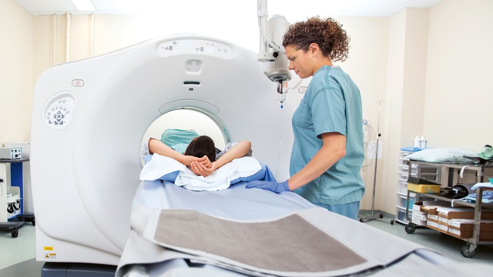 Eine Krankenschwester betreut eine Patientin, die in einem Computergraphen liegt.