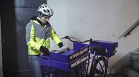 Zeitungszustellung: Zustellerin mit Fahrrad