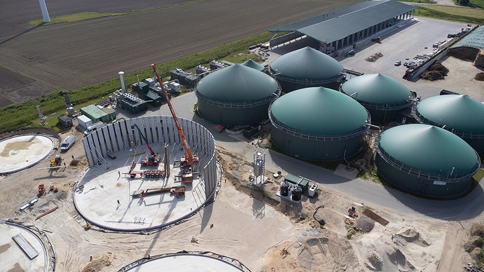 Vogelperspektive einer Biogasanlage mit sechs fertigen Behältern und mehreren im Bau